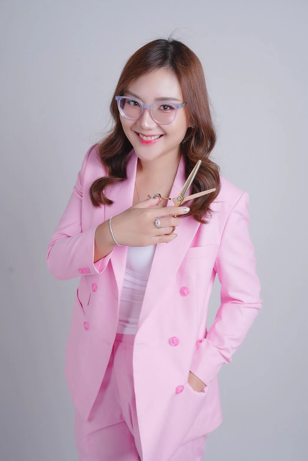 Naya, owner of Hero Paws Dog Grooming, holding grooming scissors